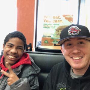 A match smiling at the camera, the young boy holding up a peace sign.